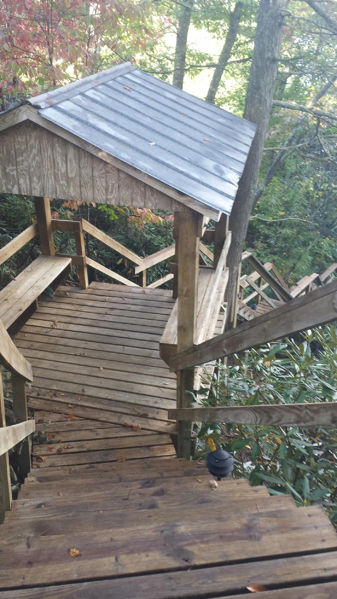 Metal roofed shelter over wooden steps on a wooded walkway — Skylight Repair & Installation work by our crew in Harvard